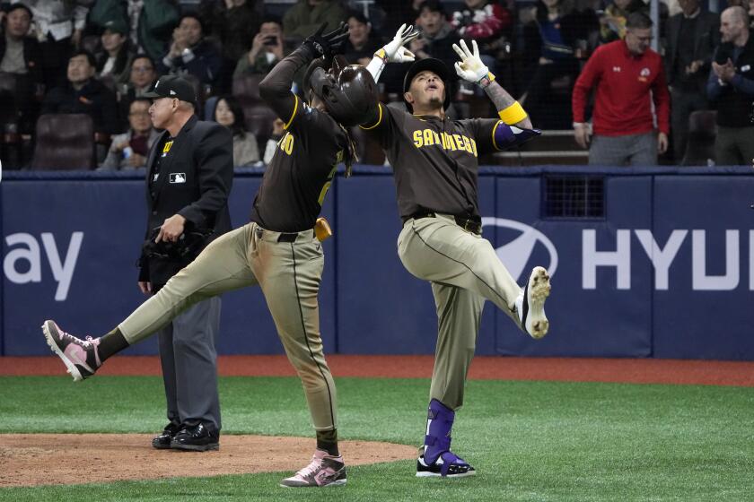 San Diego Padres' Manny Machado, right, and Fernando Tatis Jr. celebrate after Machado hit a three-run home run during the ninth inning of a baseball game against the Los Angeles Dodgers at the Gocheok Sky Dome Thursday, March 21, 2024, in Seoul, South Korea. (AP Photo/Ahn Young-joon)