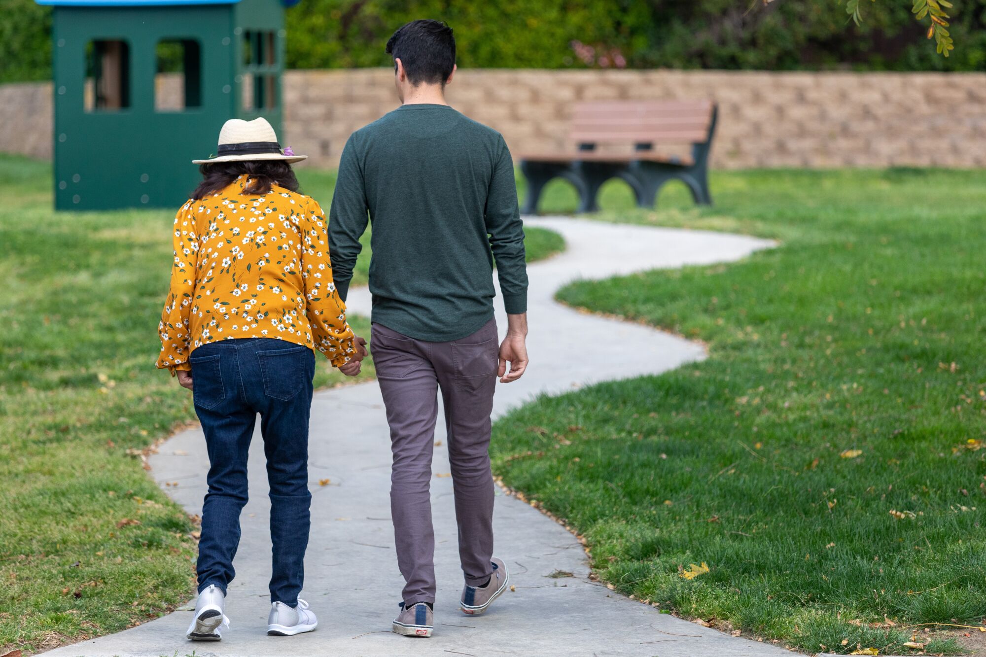 a man and his mom walk outside on a path