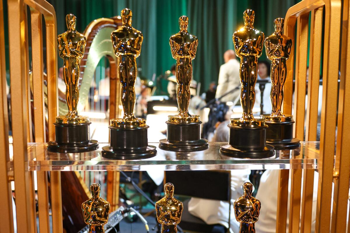 Shelves hold rows of Oscar statuettes.