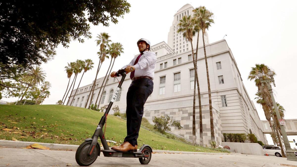 Los Angeles City Councilman Joe Buscaino rides a Bird scooter outside City Hall on Tuesday, before lawmakers approved a one-year pilot program that will allow Bird and other scooter companies to operate legally.