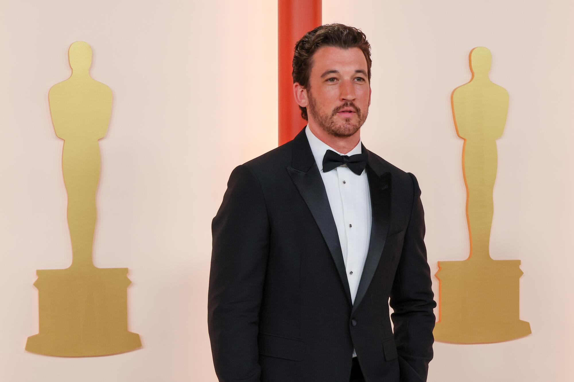 Miles Teller in a classic black tuxedo and bow tie.