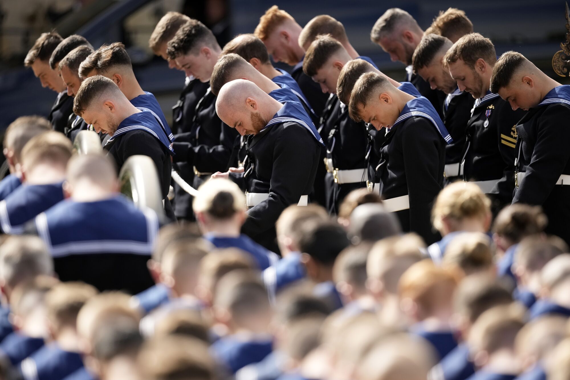 Members of the Royal Navy pay their respects by bowing their heads during the state funeral of Queen Elizabeth II.