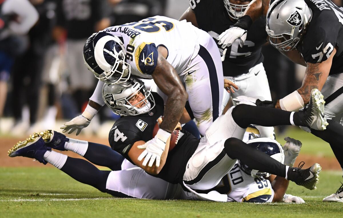 Los Angeles Rams Aaron Donald and Michael Brockers (90) sack Raiders quarterback Derek Carr. A roughing a passer penalty was calledon the play.