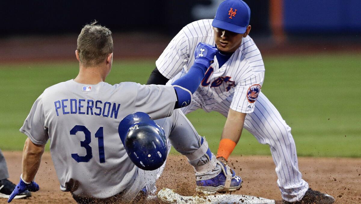 Ruben Tejada (d), de los Mets, pone out a Joc Pederson, de los Dodgers, en el tercer inning.
