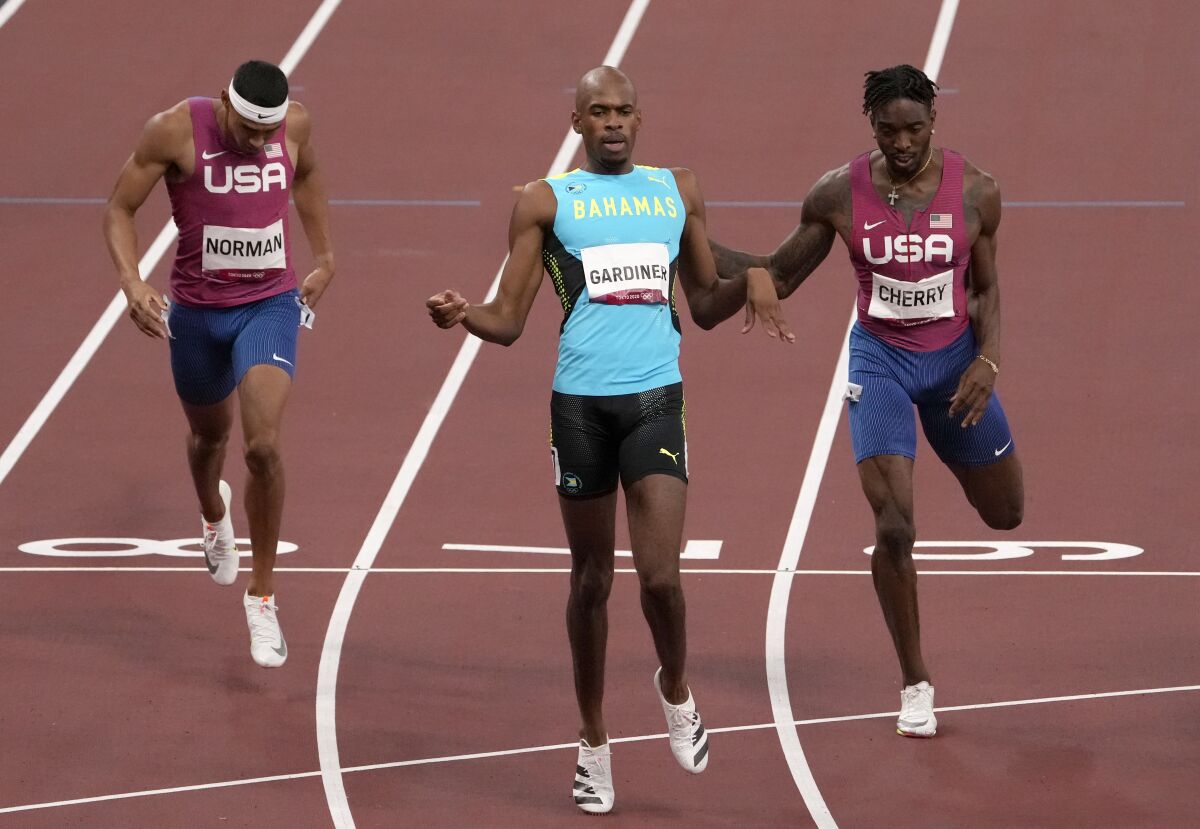 Steven Gardiner slows down after winning the men's 400-meter gold medal in front of Michael Cherry and Michael Norman.