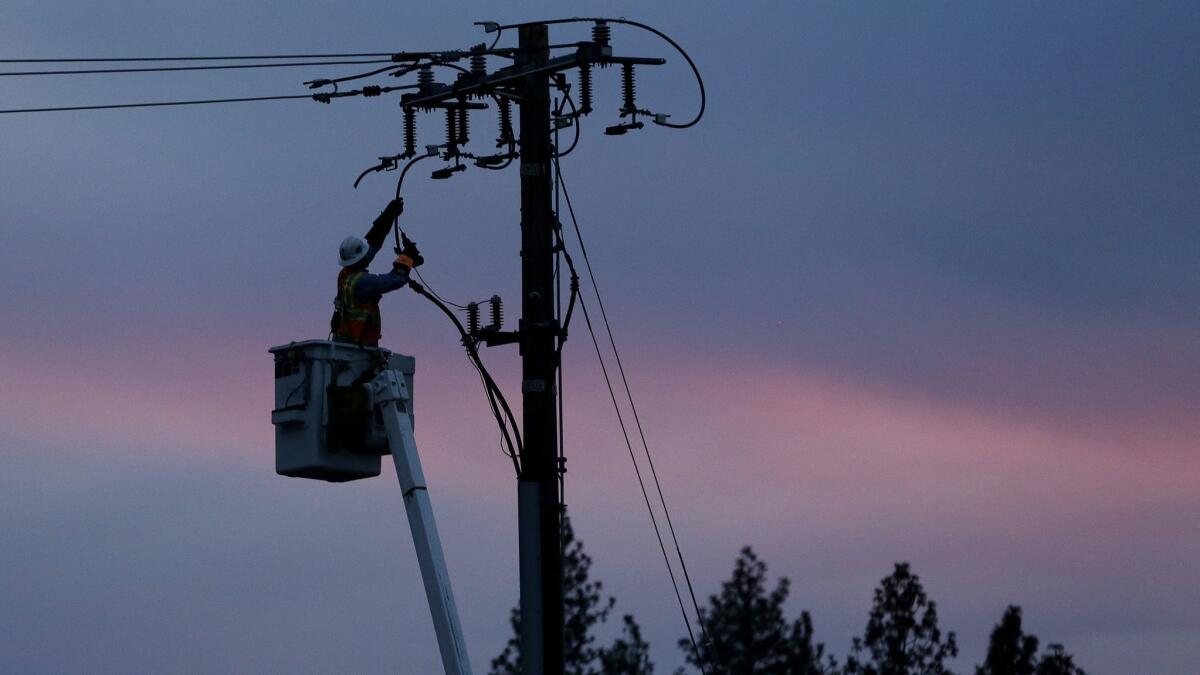 A Pacific Gas & Electric lineman works to repair a power line in fire-ravaged Paradise, Calif. on Nov. 26, 2018.