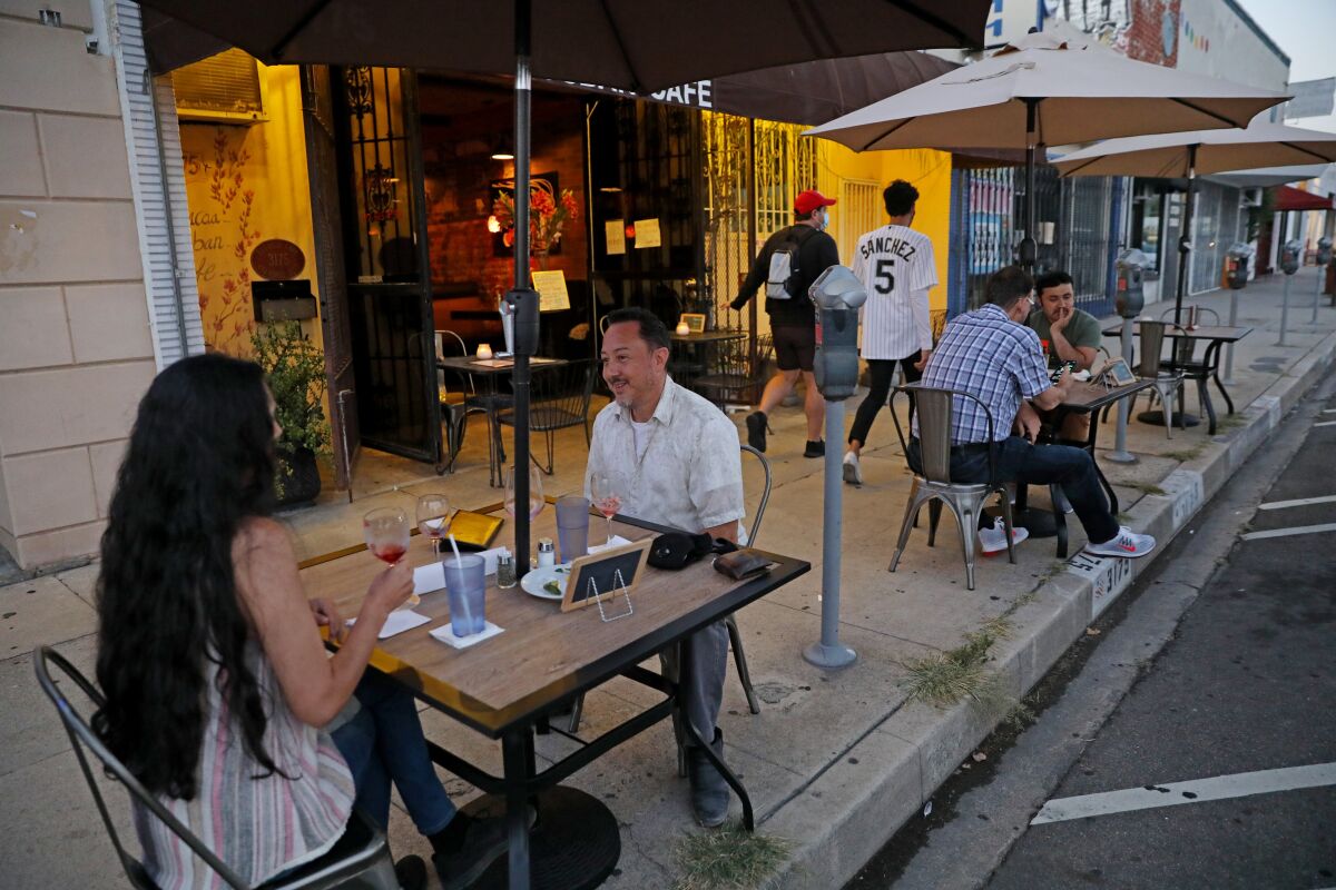People dine at an outdoor area set up on a sidewalk in Atwater Village