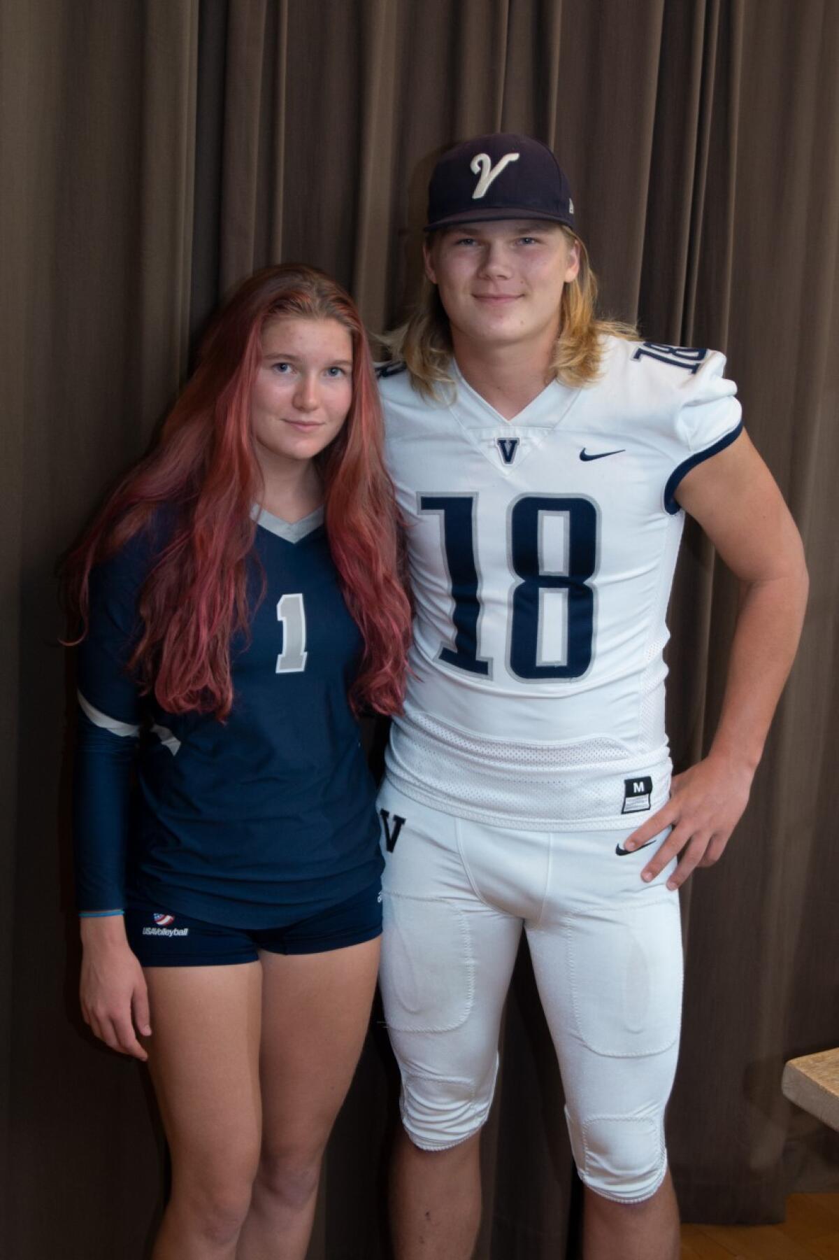 Twins Daniella and Thomas Kensinger pose for a photo in the volleyball and football uniforms.