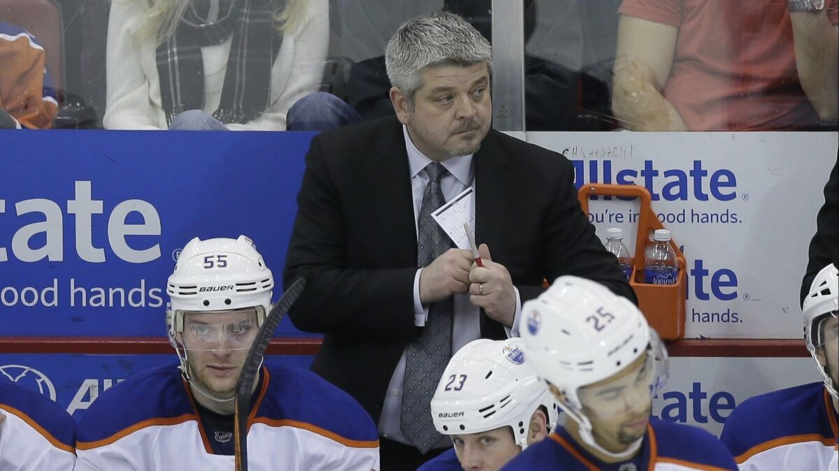 Todd McLellan watches from behind the Edmonton Oilers' bench during a game against the Detroit Red Wings in 2015.