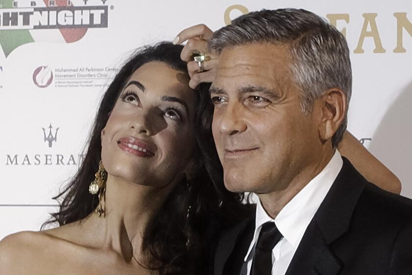 George Clooney and Amal Alamuddin pose for photographers as they arrive for the Celebrity Fight Night gala dinner in Florence, Italy, on Sept. 7.
