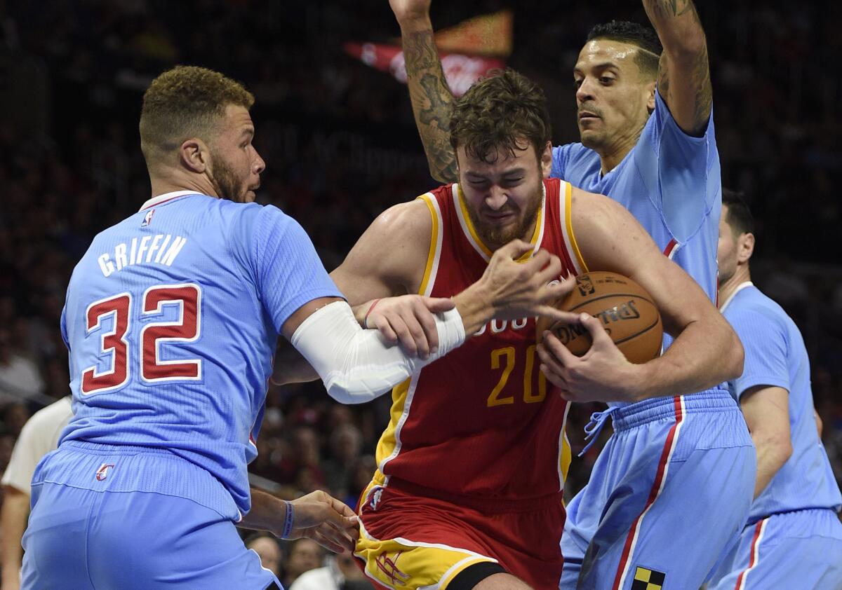 Houston forward Donatas Motiejunas is defended by Blake Griffin, left, and Matt Barnes during the third quarter of Sunday's game. The Rockets beat the Clippers, 100-98.