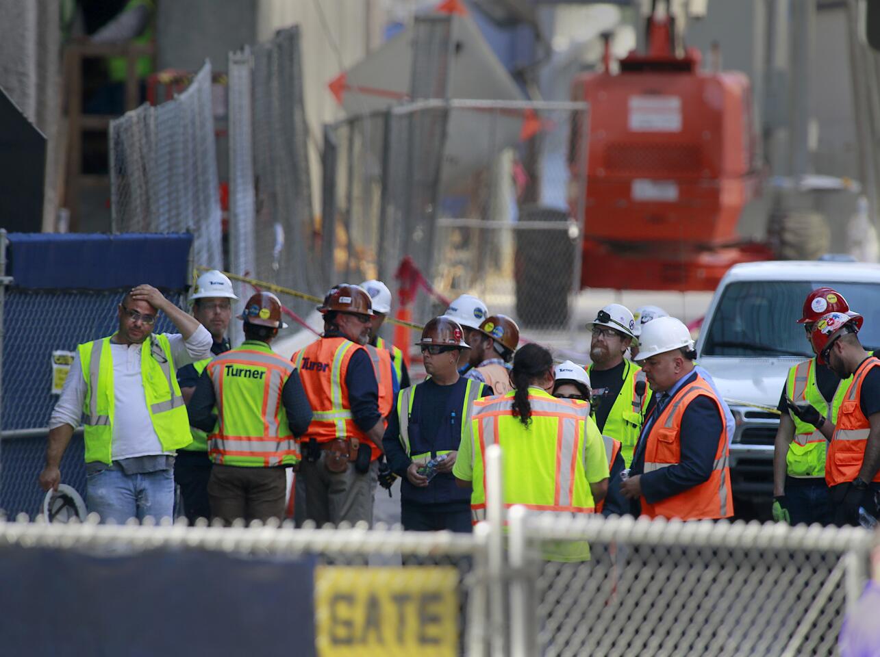 Construction workers gather near the area where an electrician died after falling 53 floors from the Wilshire Grand construction site in downtown Los Angeles.