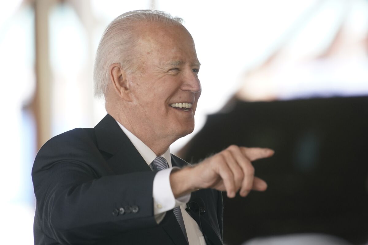 President Biden smiles and points his finger