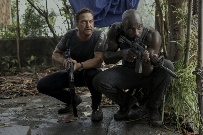 Two men holding weapons and squatting in the movie "Plane."