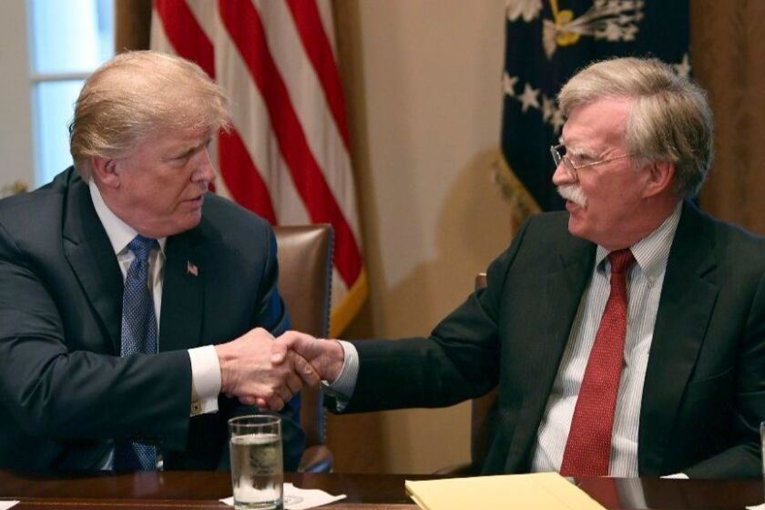 President Donald Trump, left, shakes hands with national security adviser John Bolton in the Cabinet Room of the White House in Washington, Monday, April 9, 2018, at the start of a meeting with military leaders. (AP Photo/Susan Walsh)