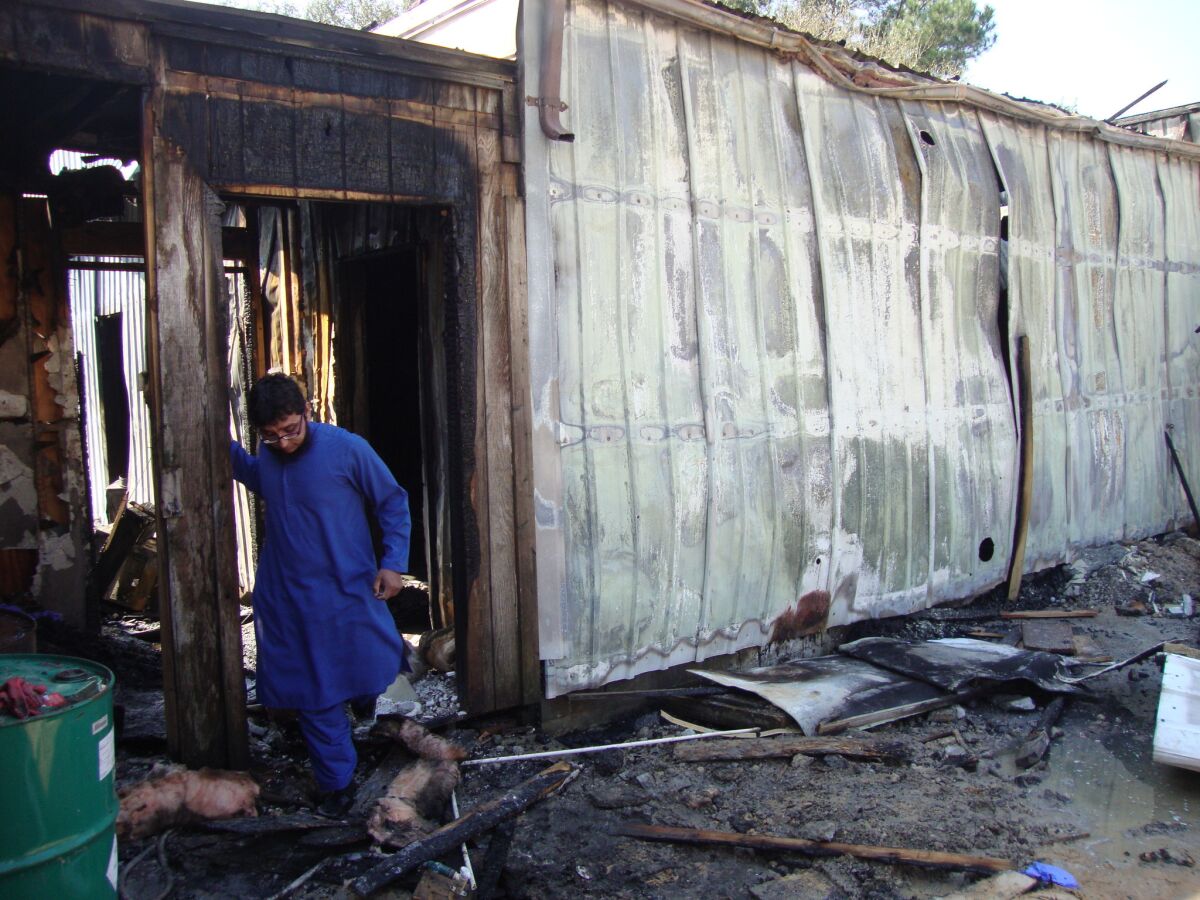 Ahsan Zahid, an assistant imam, inspects fire damage at the Quba Islamic Institute in Houston.
