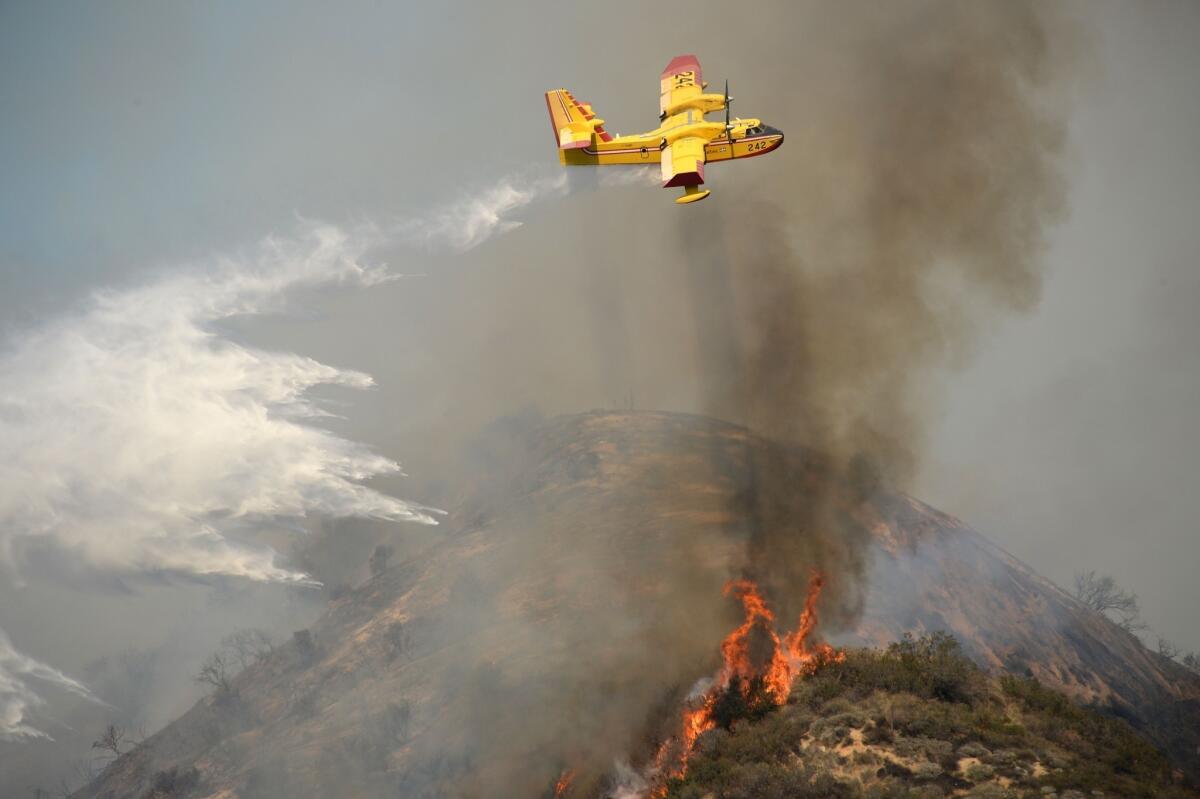 An aircraft drops water on the Colby fire in Azusa on Thursday.