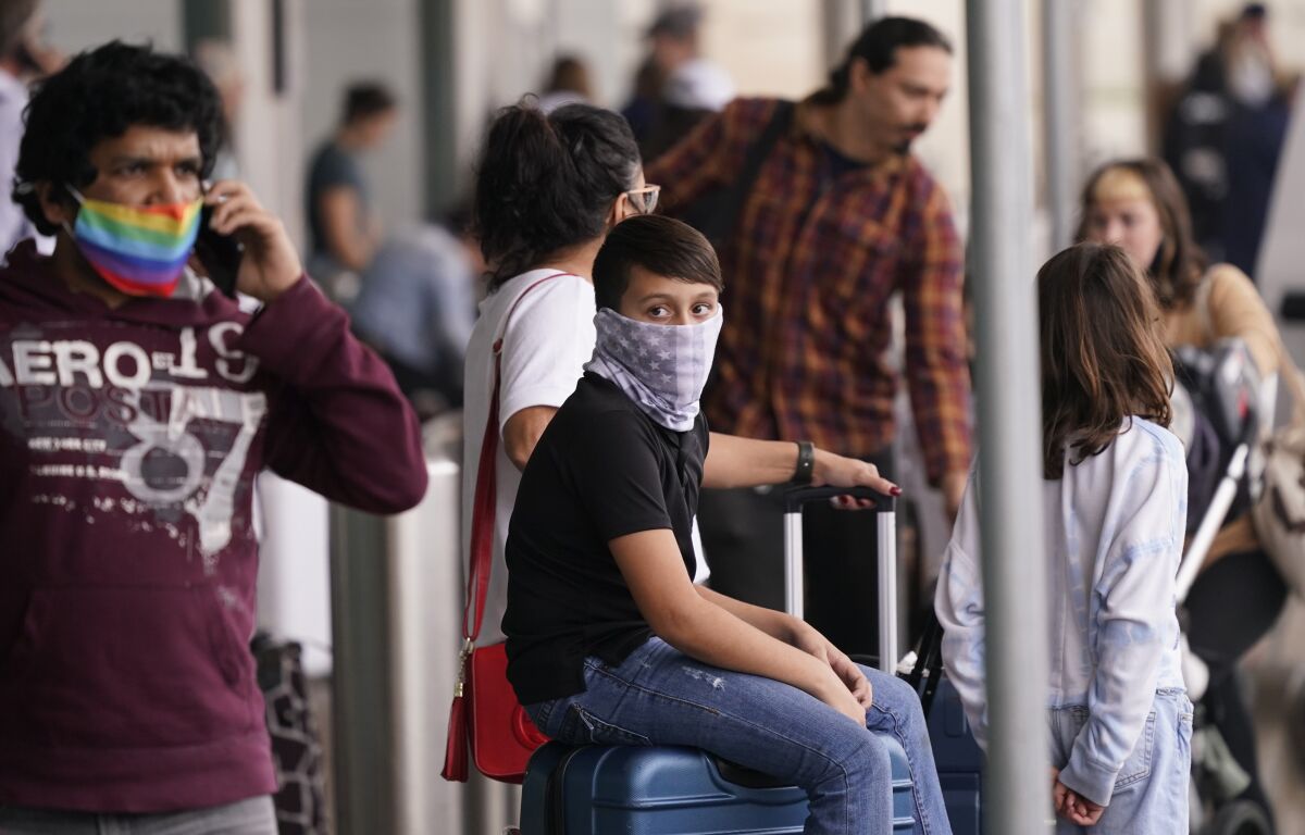 To prevent the spread of COVID-19, air travelers wear masks at Love Field in Dallas, Friday, Dec. 31, 2021. Flight cancellations surged again on the last day of 2021, with airlines blaming it on crew shortages related to the spike in COVID-19 infections. The new year is bringing more of the same old misery that air travelers in the United States have been enduring for more than a week. Airlines are blaming wintry weather and high numbers of sickouts due to the rising number of COVID-19 infections around the country. (AP Photo/LM Otero)