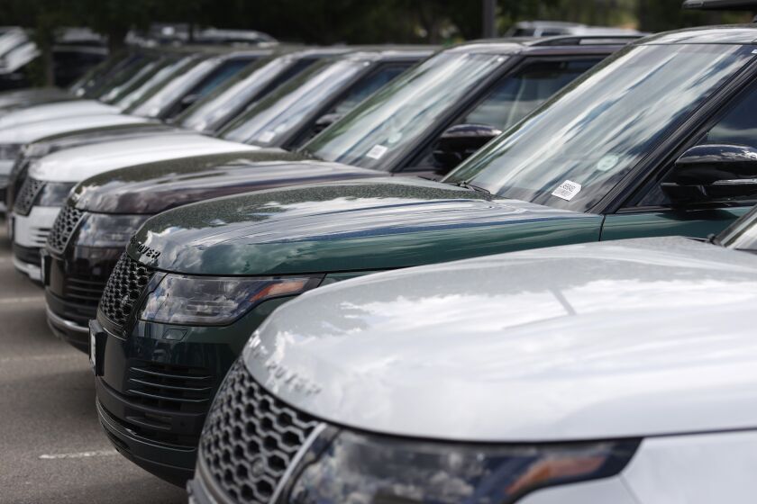 In this Sunday, June 14, 2020, photograph, a long row of unsold 2020 Range Rover sports-utility vehicles sits at a Land Rover dealership in Littleton, Colo. (AP Photo/David Zalubowski)