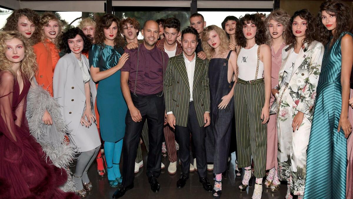 Claude Morais, center left, and Brian Wolk are surrounded by models wearing their creations backstage at the Wolk Morais "collection 5" runway show on Monday.