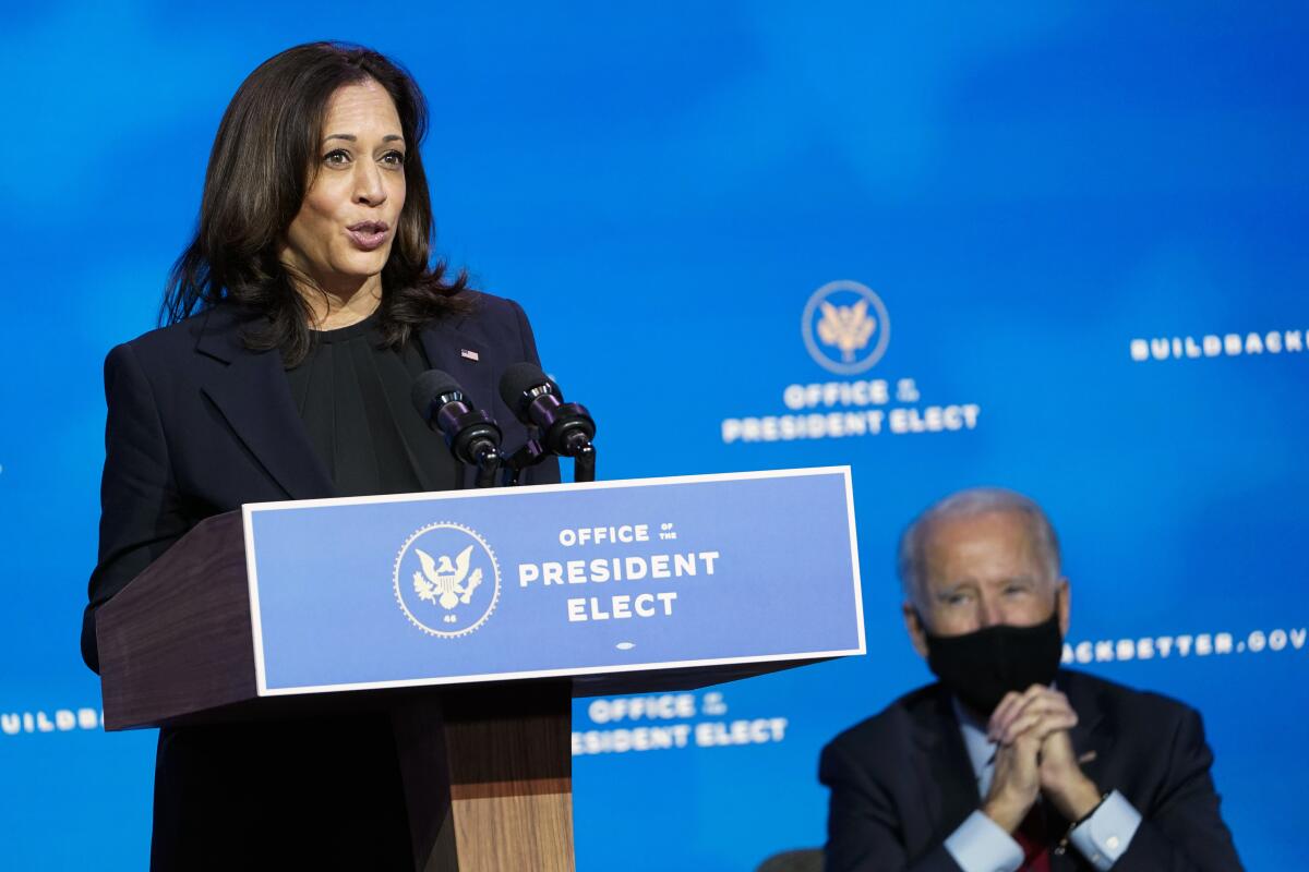 President-elect Joe Biden listens as Vice President-elect Kamala Harris speaks on Dec. 8 in Wilmington, Del.