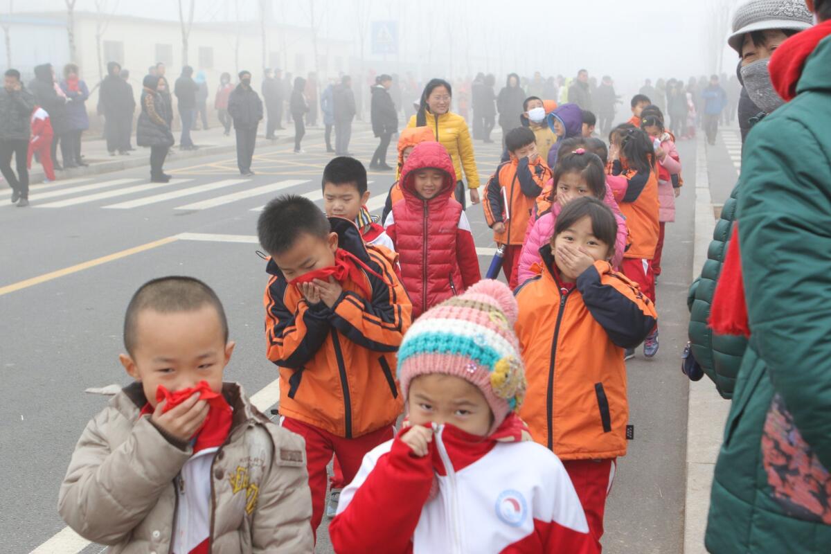 Pupils cover their noses after school in heavy smog on Dec. 23 in Binzhou, China.
