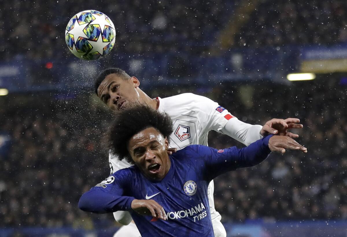 Chelsea's Willian fights for the ball against Lille's Gabriel, rear, during a Champions League soccer match.