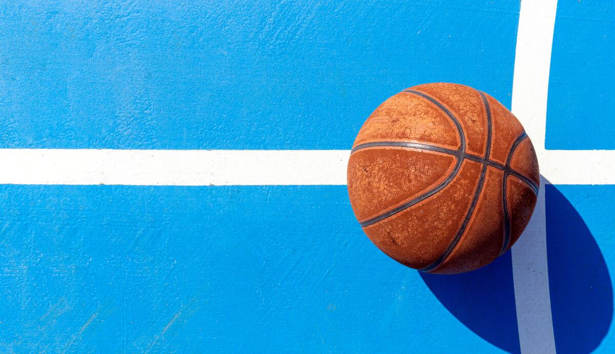 A basketball sits on a court.