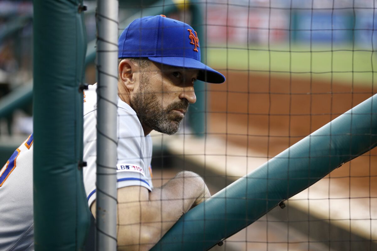 New York Mets manager Mickey Callaway leans in the dugout