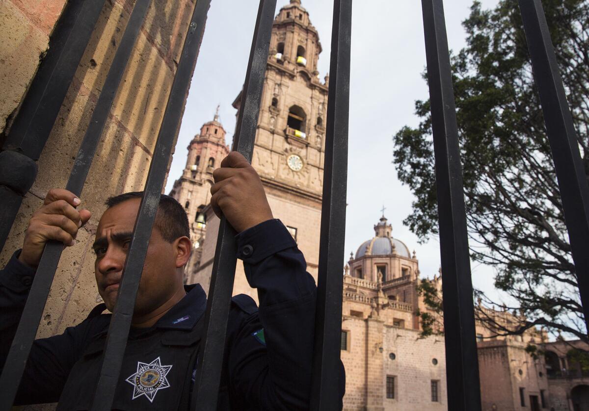 A guard at the entrance to the Morelia cathedral in Mexico on Feb. 15.