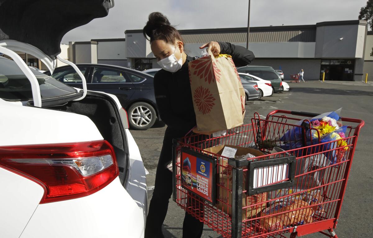 Instacart worker Saori Okawa loads groceries into her car.
