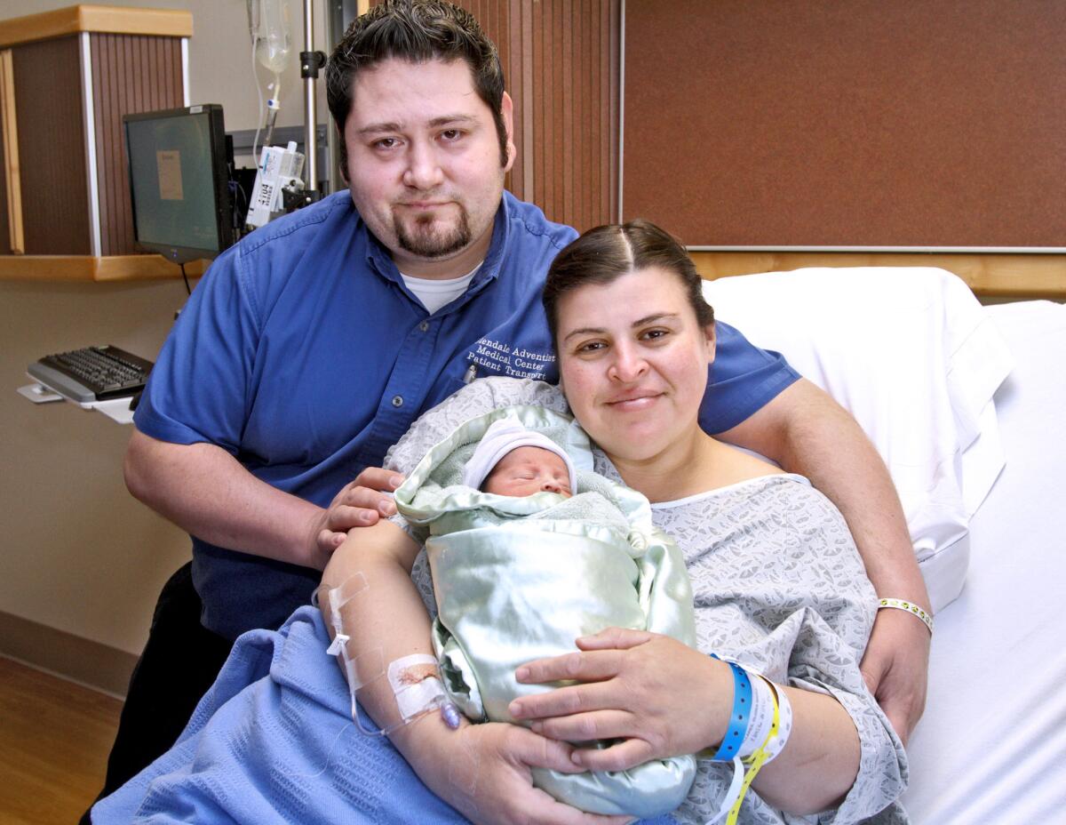 New parents Dominic and Gloria Pallares pose with their 1-day-old leap-year baby boy, Samuel Joel, at Glendale Adventist Medical Center on Tuesday.