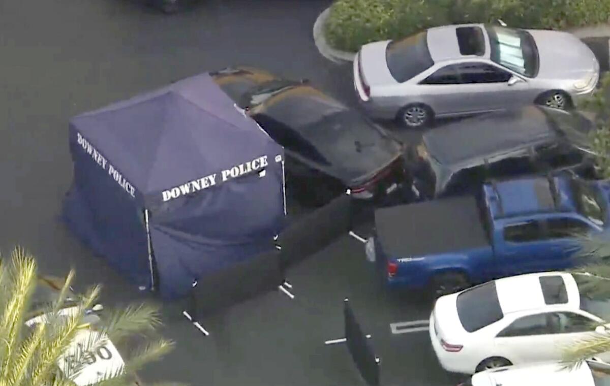 A Downey Police tent set up next to a car that had crashed into another car in a parking lot