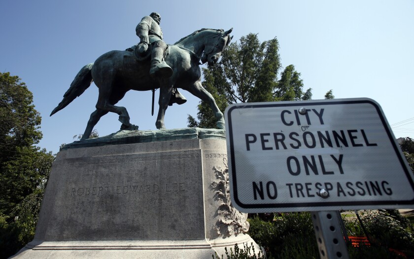 FILE - In this Aug. 6, 2018, file photo, a No Trespassing sign is displayed in front of a statue of Confederate Gen. Robert E. Lee in Charlottesville, Va. Charlottesville officials have voted unanimously to remove two statues of Confederate generals Robert E. Lee and Stonewall Jackson from two downtown parks including one that was the focus of a violent white nationalist rally in 2017. News outlets report that the vote came late Monday, June 7, 2021, after more than 50 people spoke during a virtual meeting, most in favor of removal. (AP Photo/Steve Helber, File)