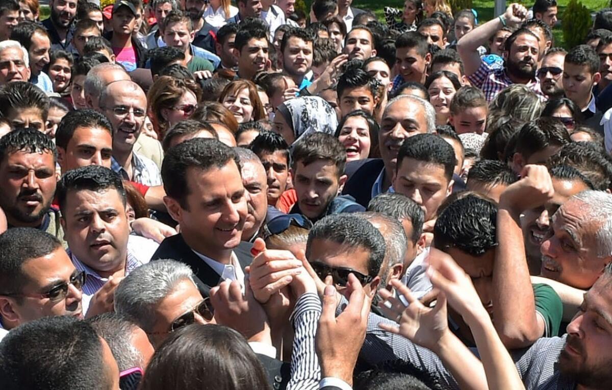 President Bashar Assad, center left, stands amid the crowd during an appearance at a school in the Syrian capital of Damascus on May 6.