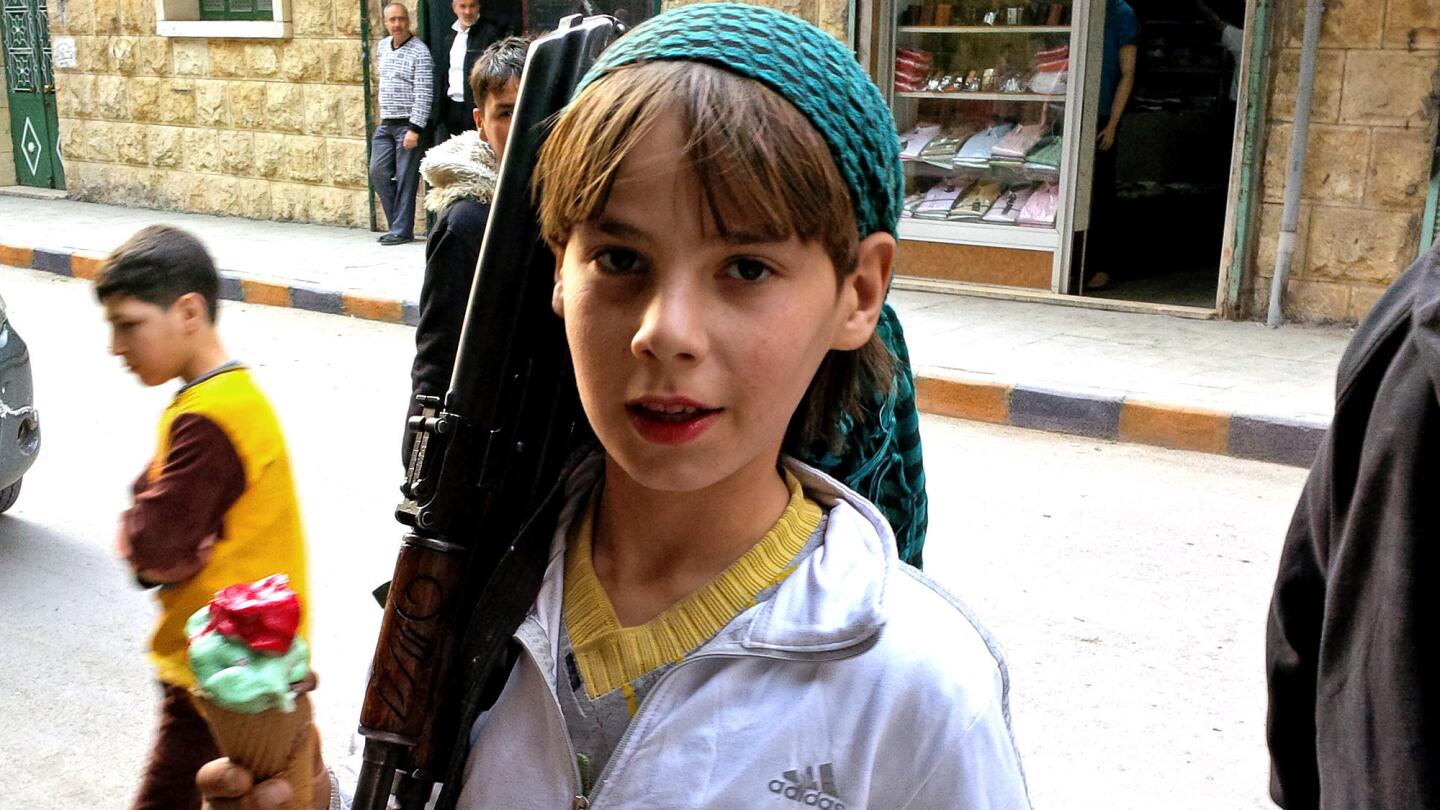 An armed boy in Aleppo, Syria, says he is a fighter with the Suqoor al Sham rebel group. He claimed to have been born in 1989, making him 24 or 25.