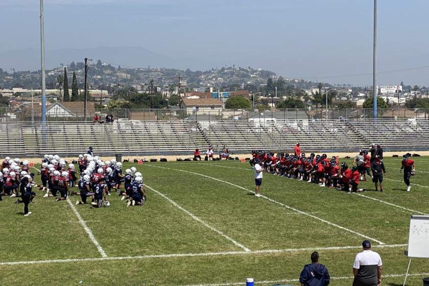 Players for Garfield, left, and Banning gather before a scrimmage April 3, 2021.