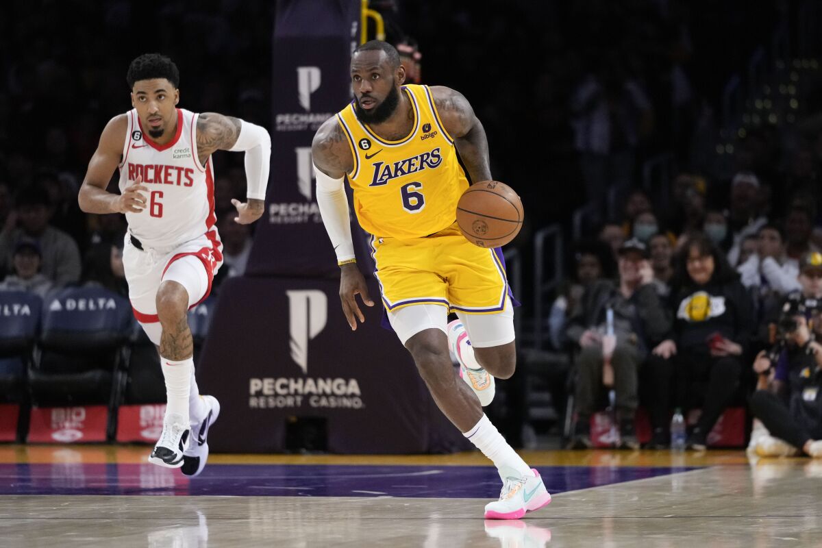Lakers forward LeBron James dribbles the ball up court ahead of Kenyon Martin Jr.