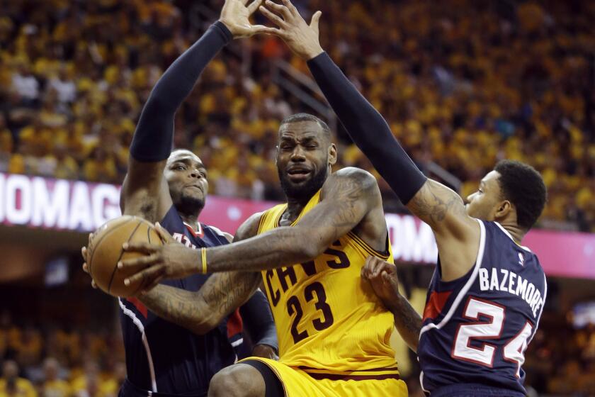 Cleveland forward LeBron James drives between Atlanta forward Paul Millsap, left, and guard Kent Bazemore, right, during the second half of Game 3 of the Eastern Conference finals.