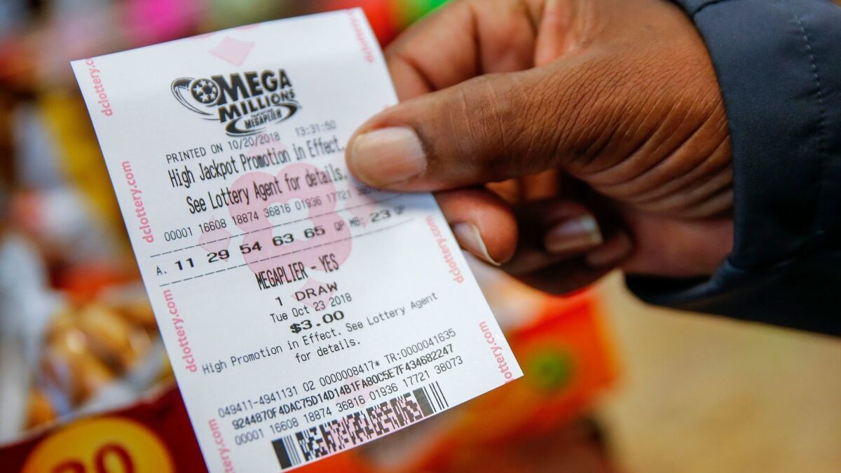 A customer shows a Mega Millions lottery ticket he bought Saturday at a retailer in Washington, D.C.