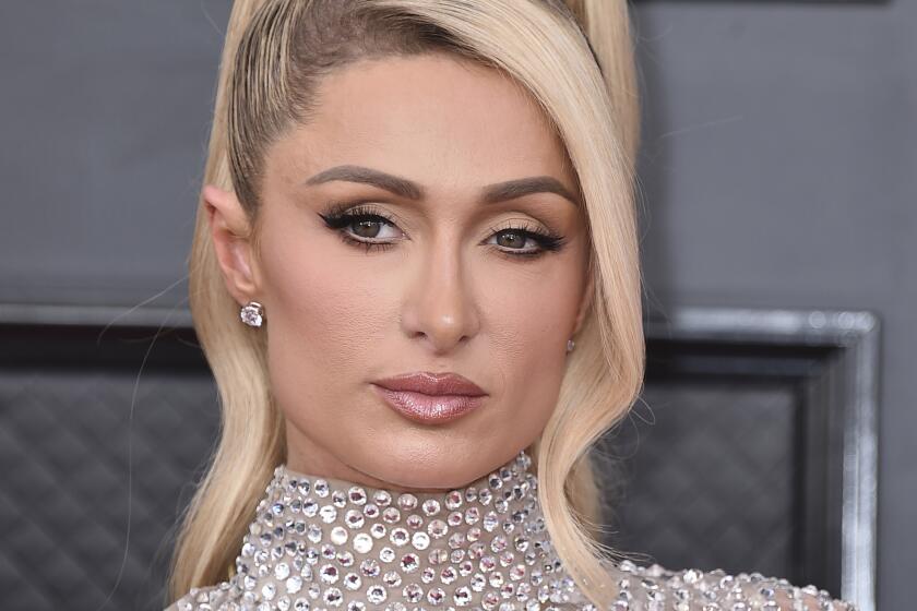Paris Hilton wearing a high ponytail and a silver sequined dress