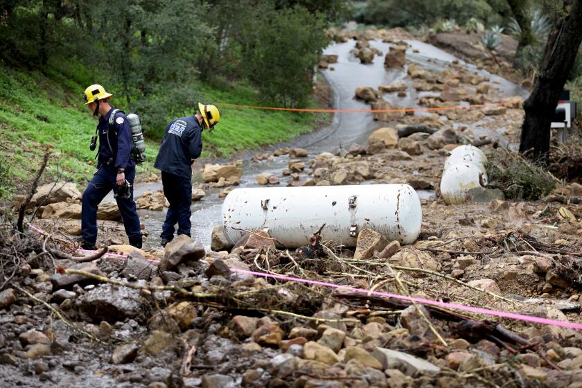 SUMMERLAND, CA - JANUARY 10: Montecito Summerland Fire Protection District responds to a rockslide where two 500-gallon propane tanks were washed up along the 800 block of Toro Canyon Road, Toro Canyon, Tuesday, Jan. 10, 2023 in Summerland, CA. A spokesperson with the fire district said the tanks were found in the early afternoon yesterday. One of the tanks is empty and the other is a one third full and were from a home. They were continuing to monitor the air from a leak coming from one of the tanks. (Gary Coronado / Los Angeles Times)