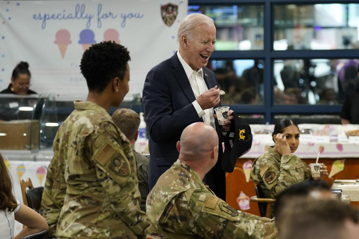 President Biden eats ice cream as he meets with American service members and their family at Osan Air Base.