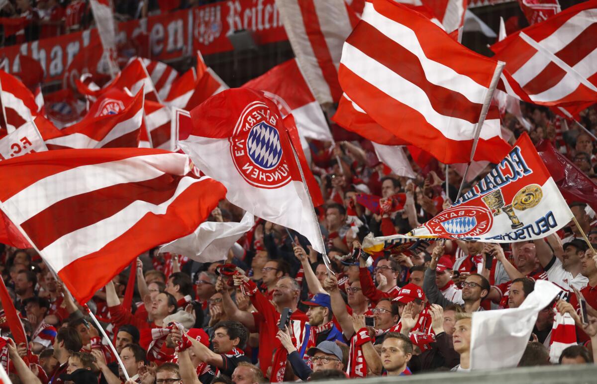 FILE - Bayern fans wave flags prior to the semifinal first leg soccer match between FC Bayern Munich and Real Madrid at the Allianz Arena stadium in Munich, Germany, Wednesday, April 25, 2018. Bayern Munich's chief executive Oliver Kahn has defended the German soccer club’s contentious sponsorship agreement with Qatar. Kahn said Monday, July 4, 2022, he's sure their partnership has helped bring positive change to the oil-rich Persian Gulf state. (AP Photo/Matthias Schrader, File)