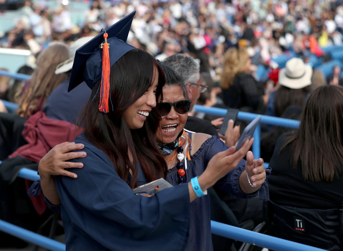 Graduate Kimberly Ly makes a walking selfie video with her grandmother.