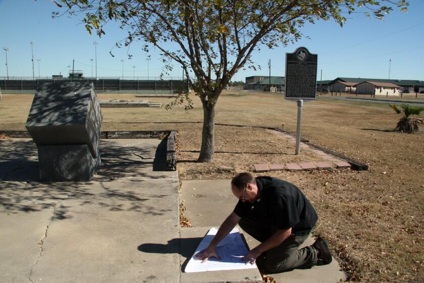 William McWhorter, program coordinator for the History Programs Division of the Texas Historical Commission, examines a schematic drawing of a former World War II internment camp to the present day site at Crystal City, Texas on Tuesday, Nov. 30, 2010. The concrete was the floor for a building at the camp. The Texas Historical Commission is attempting to preserve the remains of camps that housed German, Italian and Japanese detainees in Texas during the WWII years. (AP Photo/Michael Graczyk)
