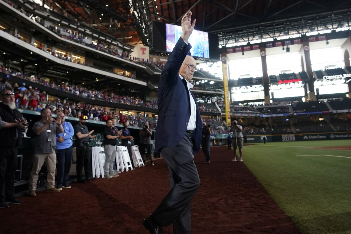 FILE - Baseball great and former Texas Rangers pitcher Nolan Ryan waves to the crowd as he takes the field for a screening of a documentary film about him, after a baseball ball game between the Atlanta Braves and Texas Rangers in Arlington, Texas, Sunday, May 1, 2022. (AP Photo/LM Otero, File)