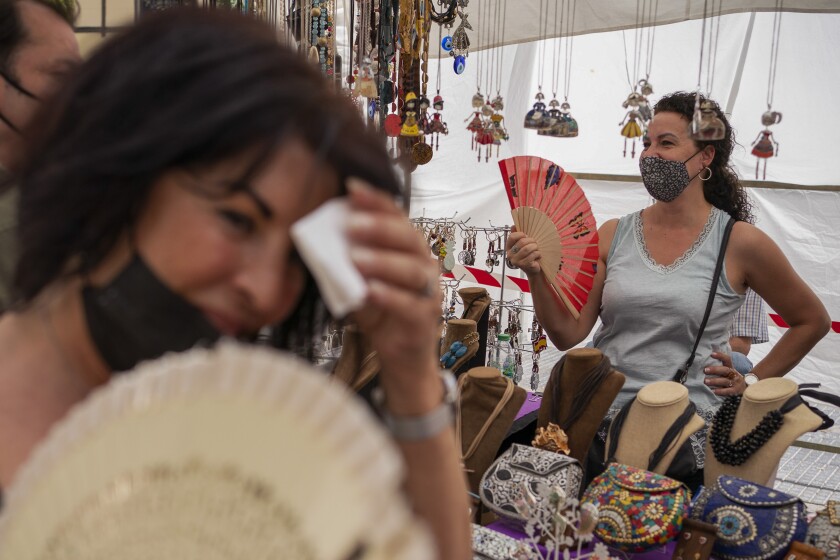 Women using handheld fans to cool themselves