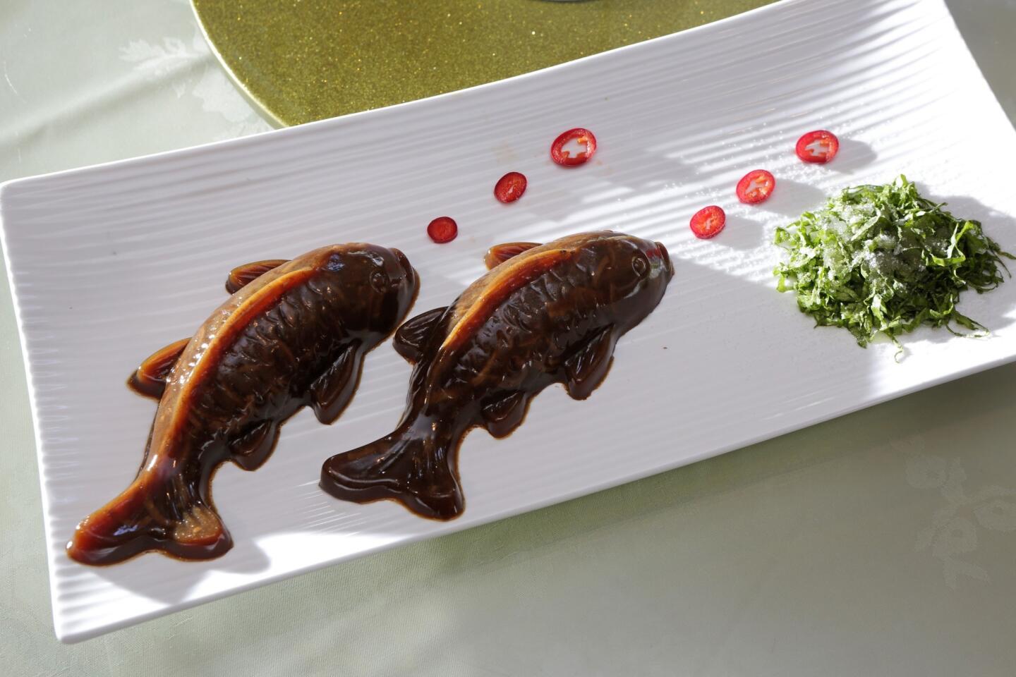 The koi jello is a chilled concoction of jellied pigskin molded into the shape of a swimming fish, presented with rings of sliced pepper emerging from its mouth.