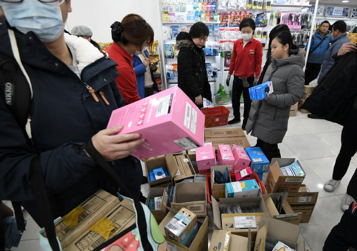 Tourists buy respiratory masks at a shop in the Myeongdong shopping district in Seoul on Jan. 29, 2020.